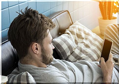 Man looking at mobile on sofa