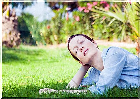 Happy woman on the grass symbolizing how Buddhism to face chaos