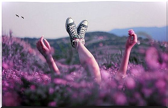 girl lying in field enjoying happiness in small acts