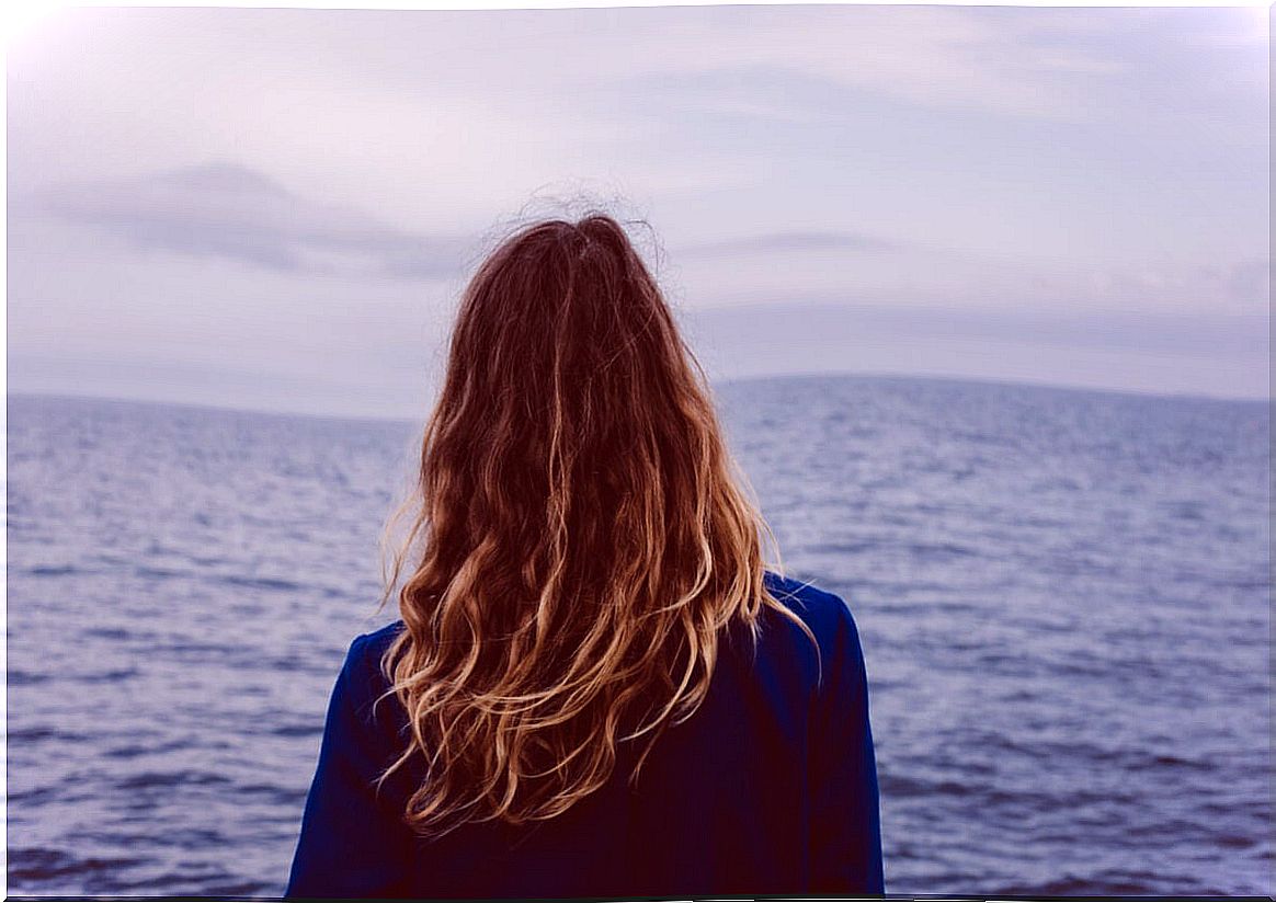 Woman looking at the sea trying to live with meaning