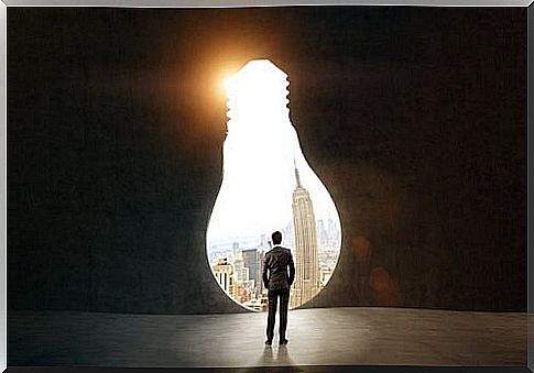 Man before figure in the shape of a light bulb applying positive reframing