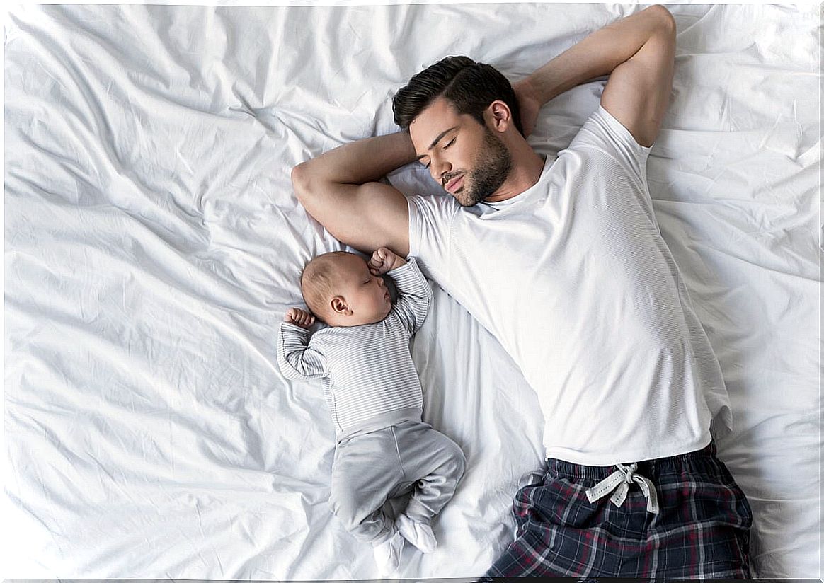 Father sleeping with a baby