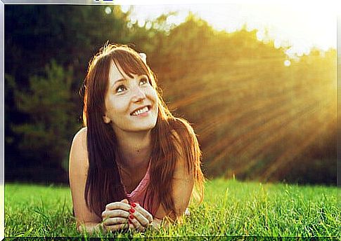 Smiling girl looking at the sun and thinking optimistically