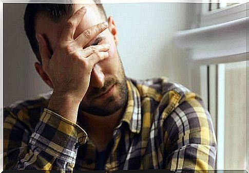 Man covering his forehead for fear of illness