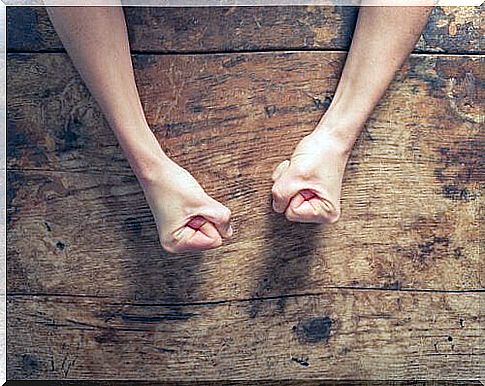 Fists of a person in anger on the table